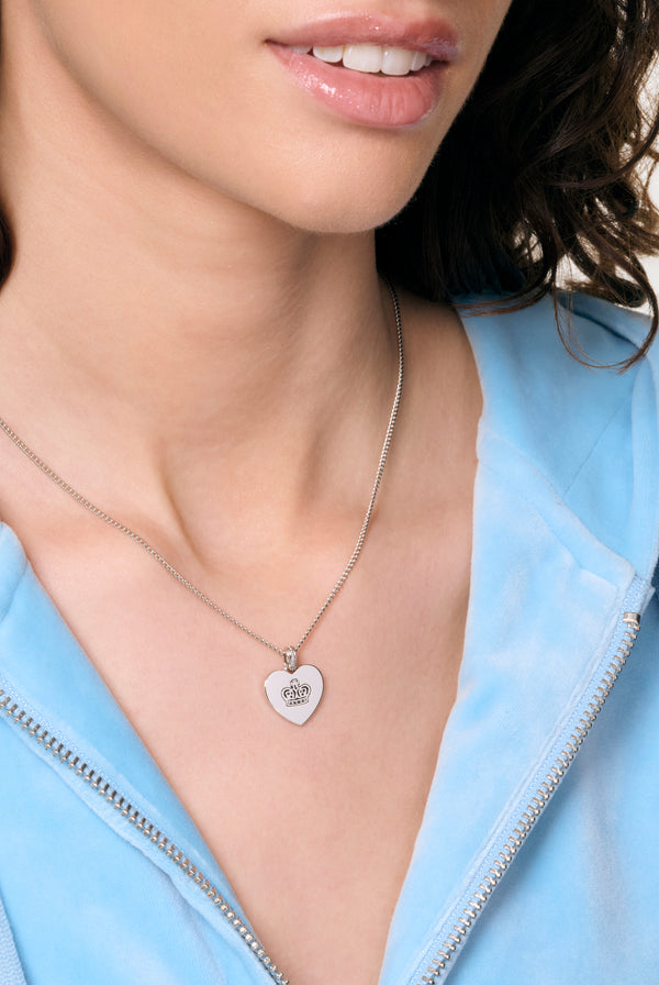 Displays a model wearing the Silver Tone 'Juicy' branded reversible heart pendant 