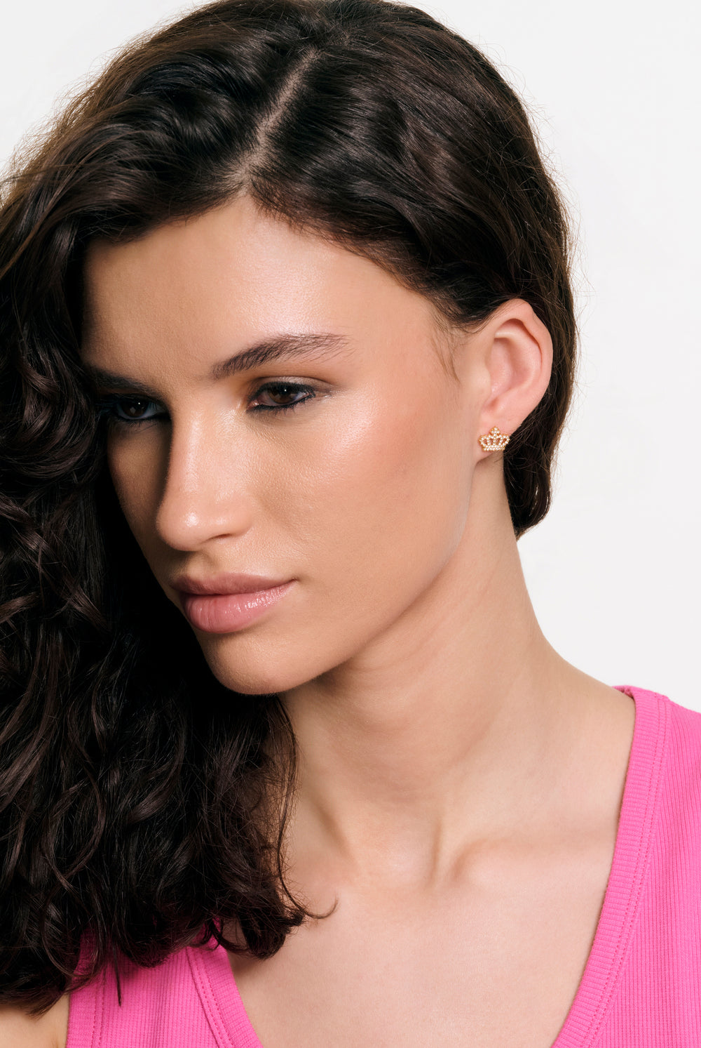 Displays a model wearing the Gold Tone 'Juicy' branded crystal motif crown stud earrings 