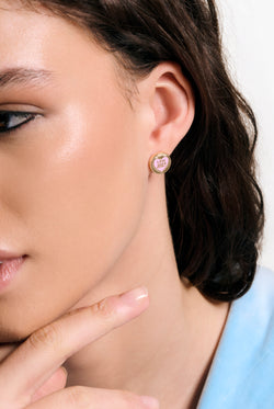 Displays a model wearing the Gold Tone 'Juicy' branded love juicy enamel stud earrings 