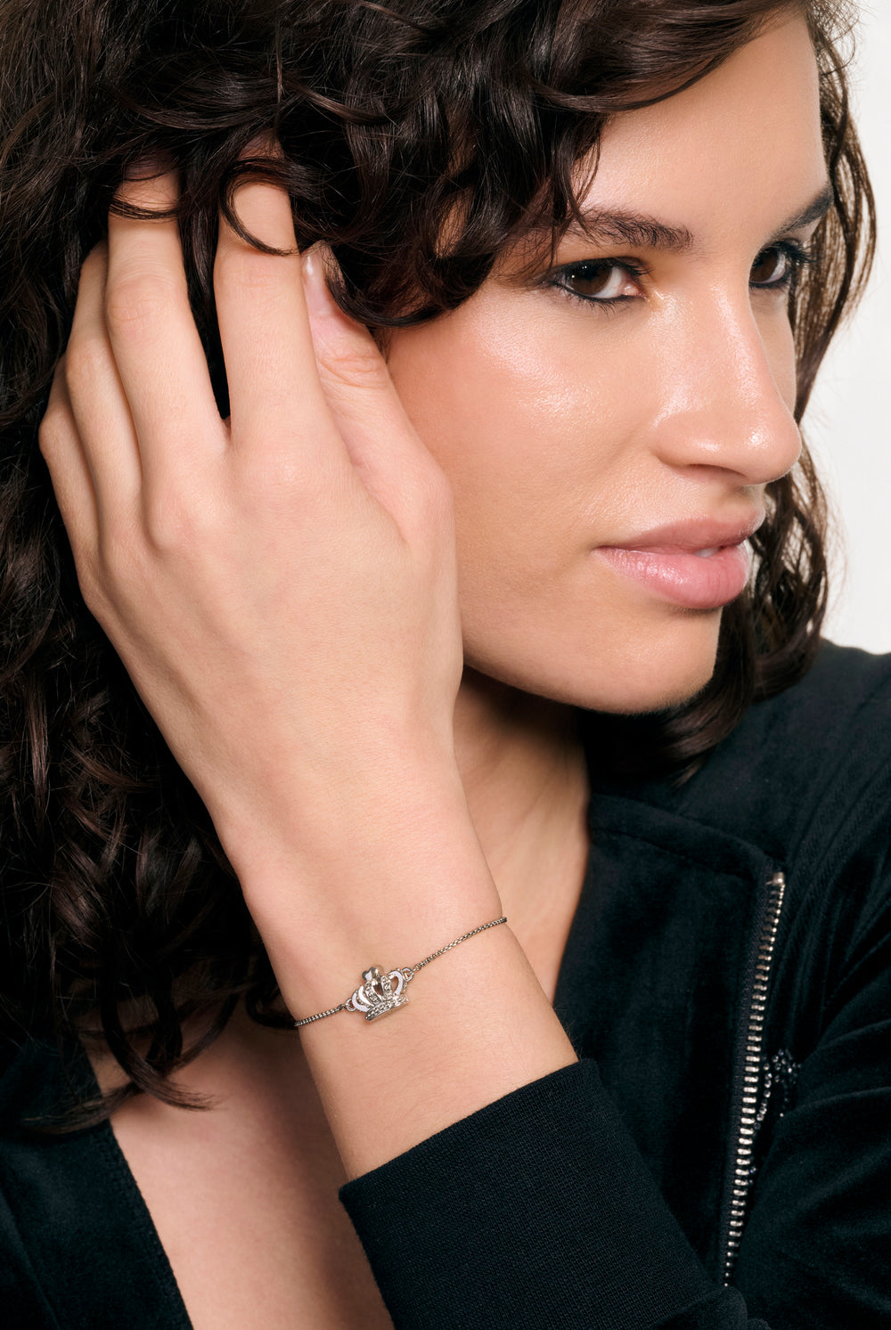Displays a model wearing the Silver tone 'Juicy' branded icon crown adjustable bracelet 