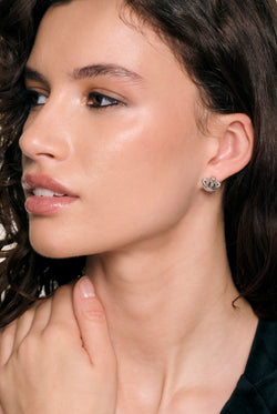 Displays a model wearing the Silver Tone 'Juicy' branded icon crown stud earrings 