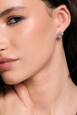 Displays a model wearing the Silver Tone 'Juicy' branded icon crown stud earrings 