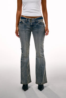 Displays a model wearing the Vintage Wash 'Juicy' branded Low Rise flared embroiled jeans 