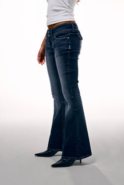 Displays a model wearing the 'Juicy' branded mid wash low rise flare embroidered jeans
