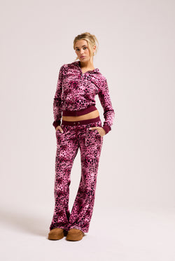 Displays a model wearing the Pink Leopard print 'Juicy' branded pocketed tracksuit bottom featuring the matching top 