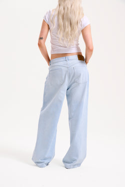 Displays a model wearing the Bleached 'Juicy' branded denim distressed wide leg jeans 