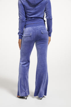 Displays a model wearing the Grey&blue 'Juicy' branded Low Rise Flare Classic Velour Track Pant