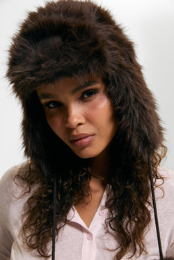 Displays a model wearing the Java 'Juicy' branded Long Pile Trapper Hat