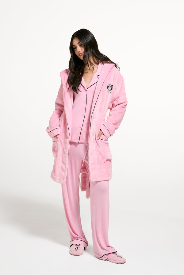 Displays a model wearing the Juicy Pink 'Juicy' branded Plush Crest Robe