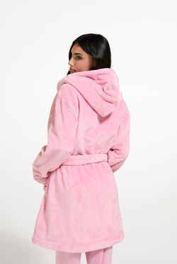 Displays a model wearing the Juicy Pink 'Juicy' branded Plush Crest Robe