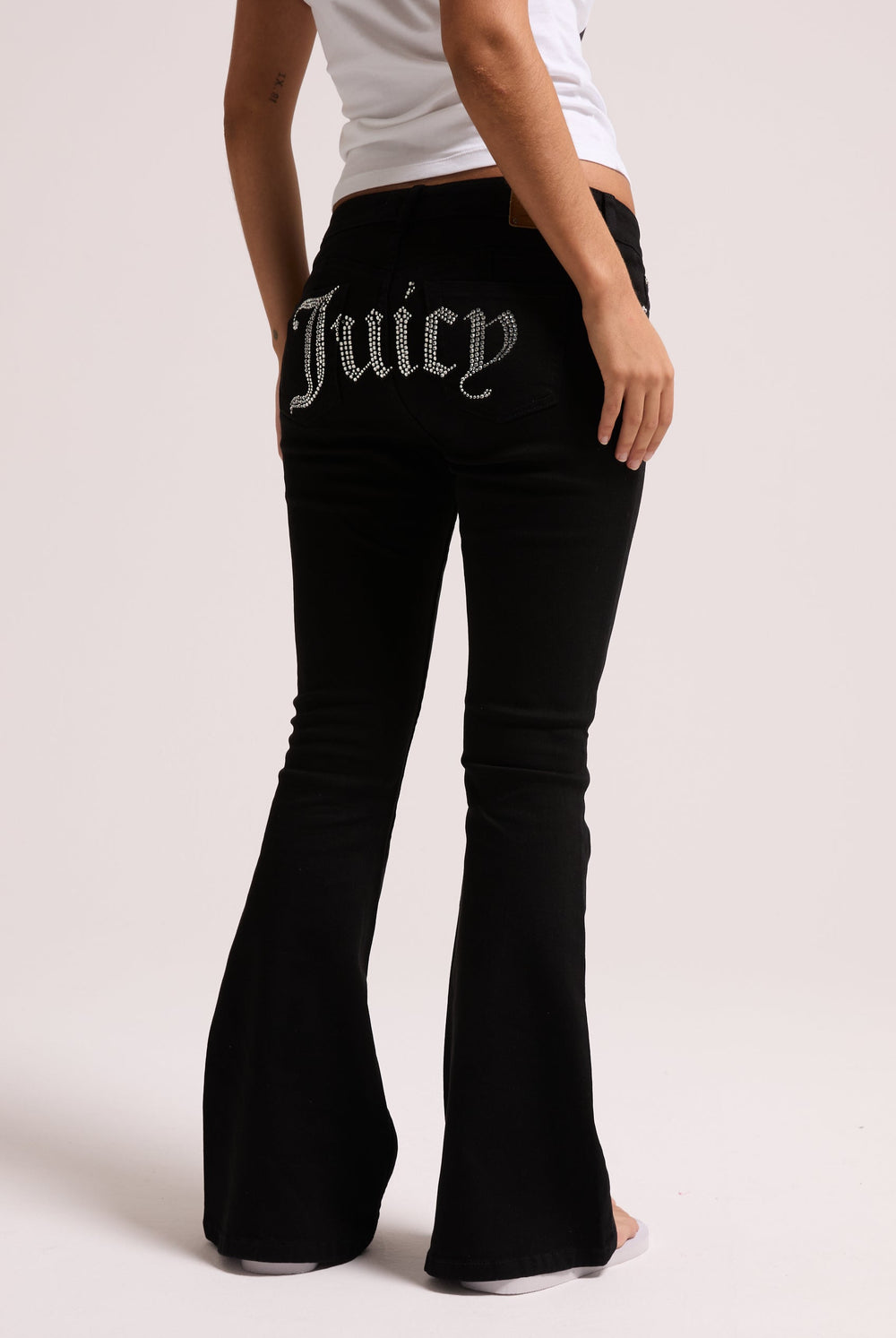 Displays a model wearing the Black stretch 'Juicy' branded twill low rise flare jeans 