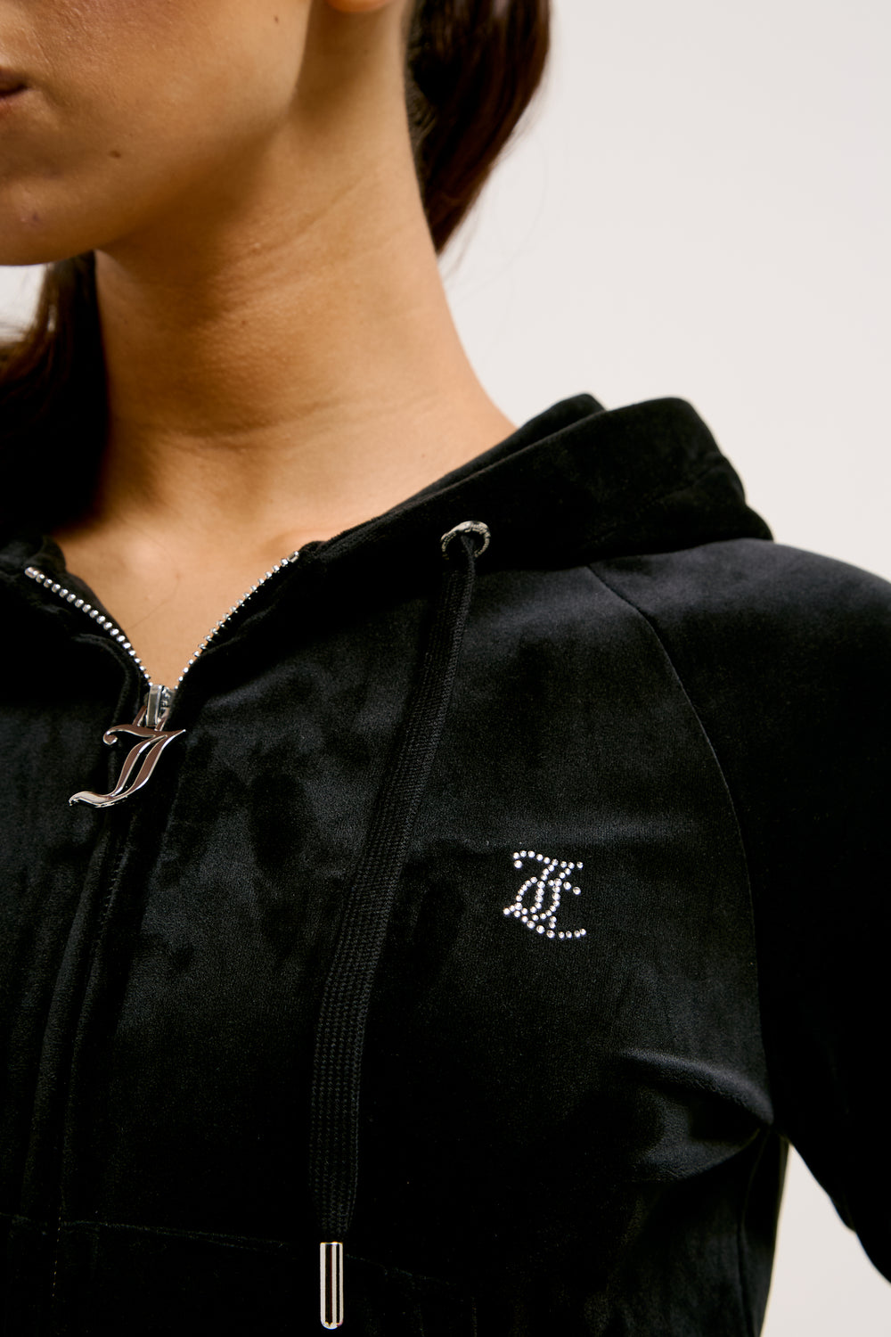 Black jacket with a Juicy Couture logo on the chest against a neutral background