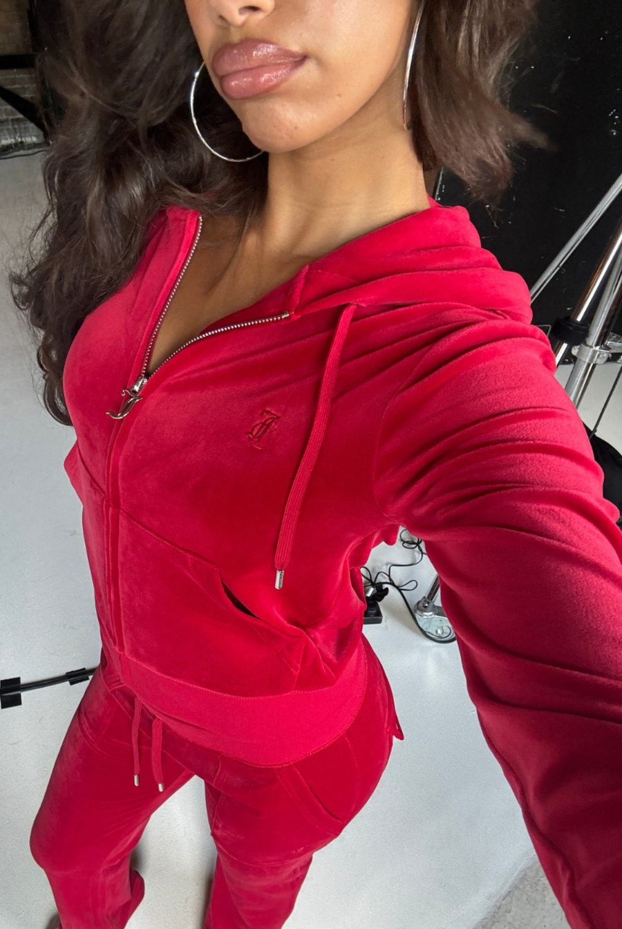 Displays a model wearing the Astor Red 'Juicy' branded red classic velour Robertson hoodie 