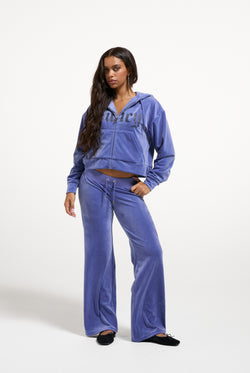 Displays a model wearing the Greyblue 'Juicy' branded Old Gothic Diamante OG Straight Leg Trackpant