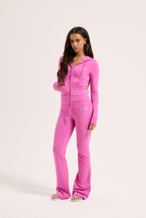 Displays a model wearing the super pink 'juicy' branded diamanté luxury jersey low rise pant 