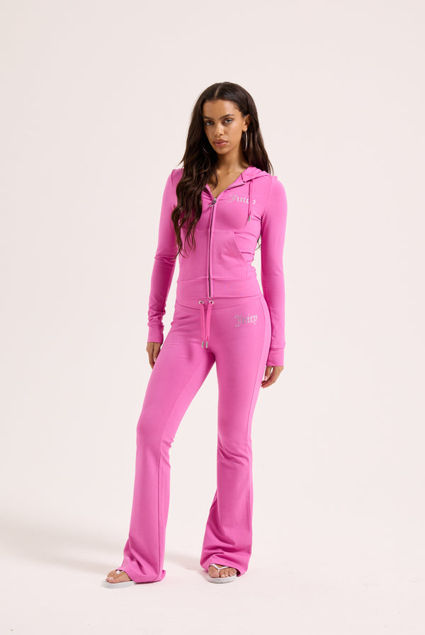 Displays a model wearing the super pink 'juicy' branded diamanté luxury jersey low rise pant 