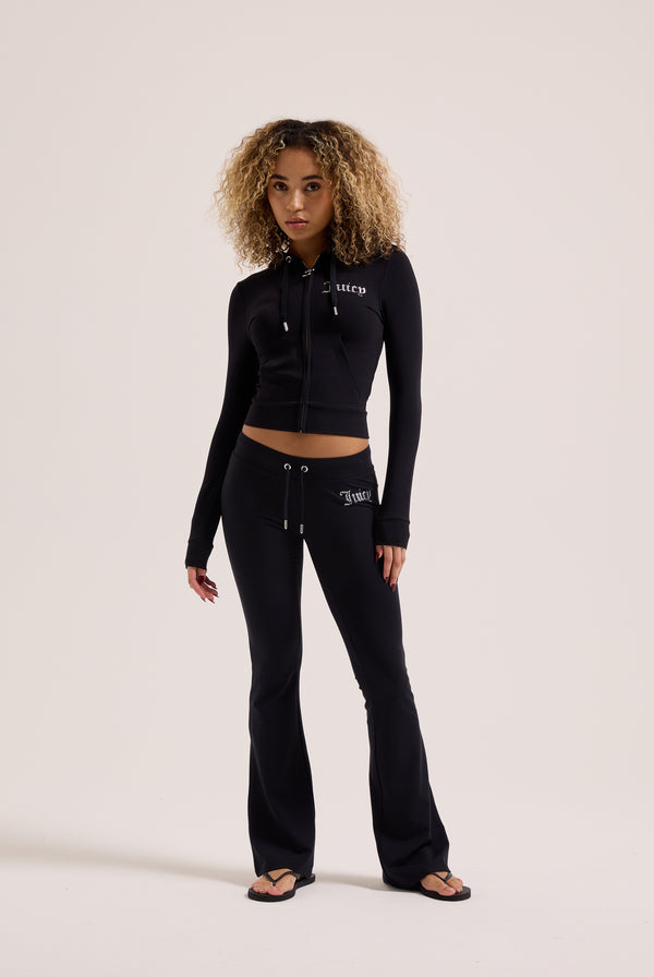 Displays a model wearing the Black Diamanté 'Juicy' branded luxury jersey low rise pants 