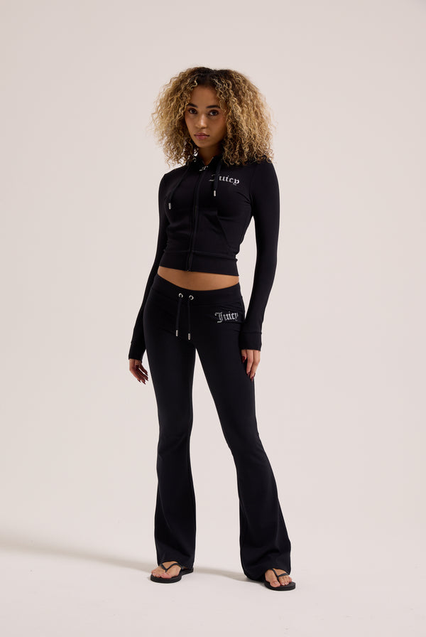 Displays a model wearing the Black Diamanté 'Juicy' branded luxury jersey low rise pants 