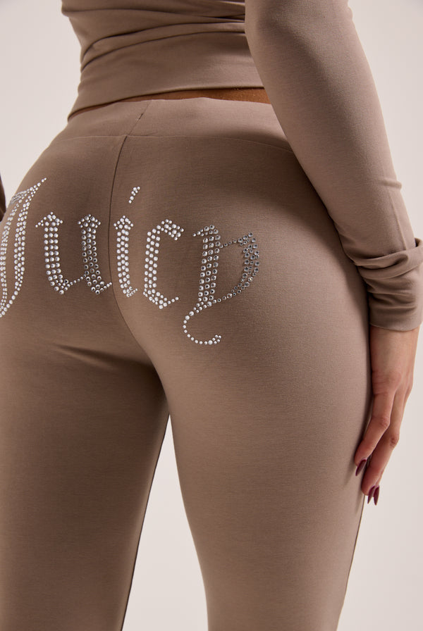 Displays a model wearing the Fungi 'juicy' branded diamanté luxury jersey low rise pant 