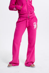 Displays a model wearing the Nostalgia Pink 'Juicy' branded Relaxed Fit Flare Fleece Trackpant