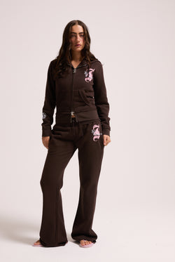 Displays a model wearing the Java longline 'Juicy' branded fleece zip through hoodie 
