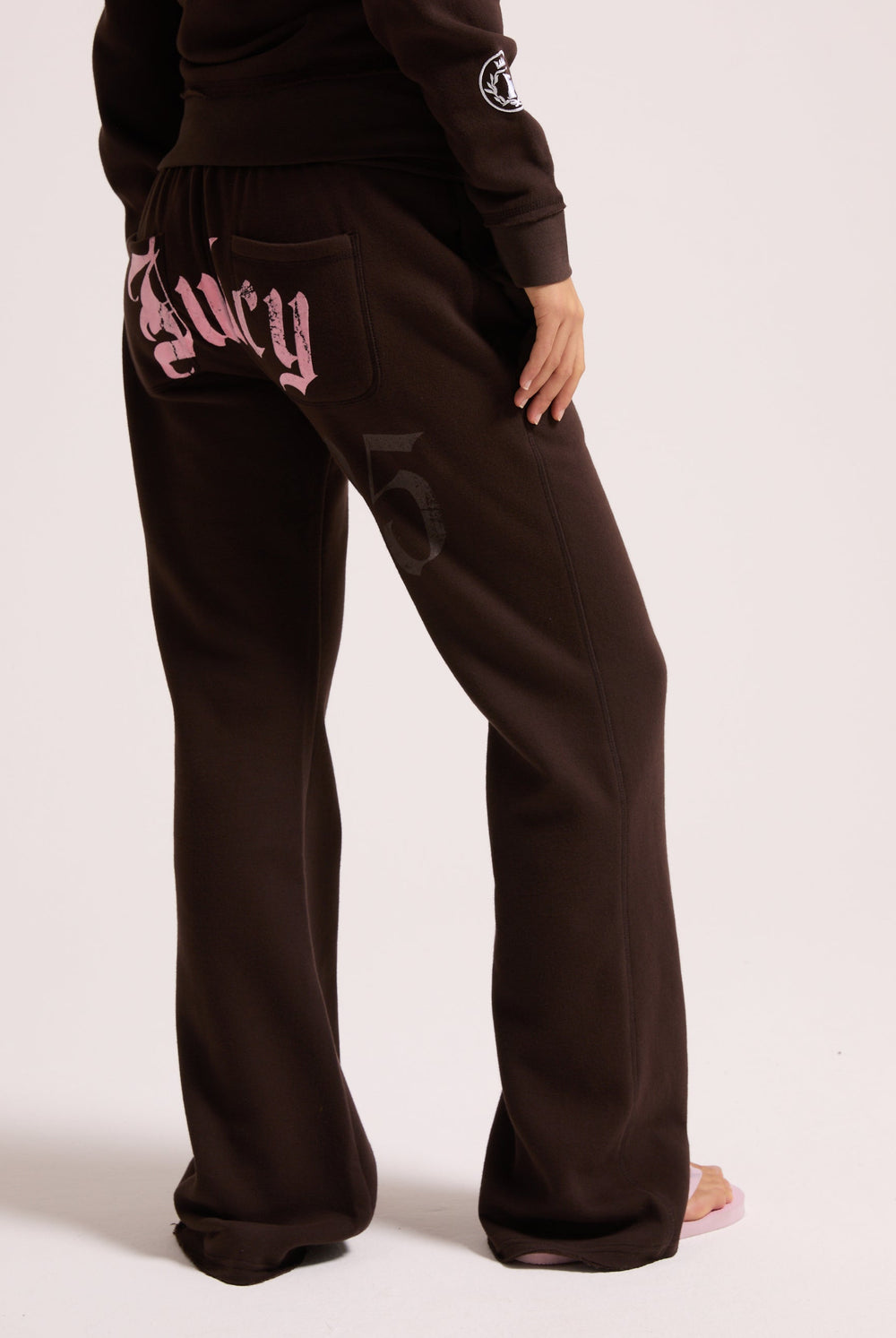 Displays a model wearing the Java 'Juicy' branded relaxed fit flare fleece trackpant
