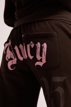 Displays a model wearing the Java 'Juicy' branded relaxed fit flare fleece trackpant featuring the juicy branding 