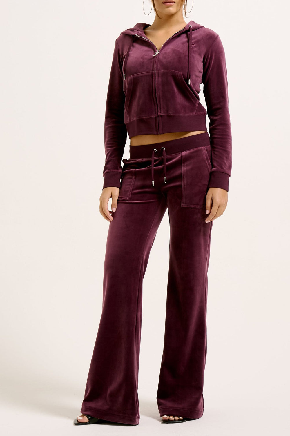 Displays a model wearing the wine tasting classic 'juicy' branded velour Robertson hoodie 
