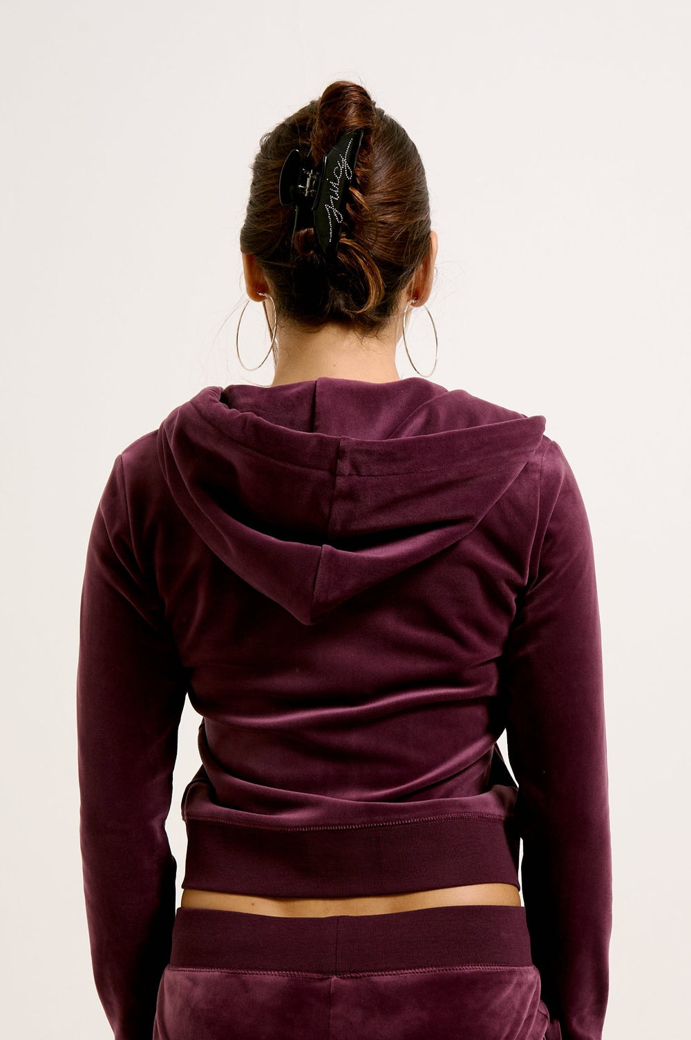 Displays a model wearing the wine tasting classic 'juicy' branded velour Robertson hoodie 