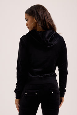 Woman wearing a black hoodie from behind on a light background