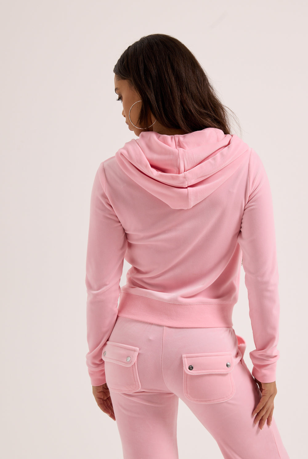 Displays a model wearing the Pink Classic 'Juicy' branded Velour Robertson Hoodie 