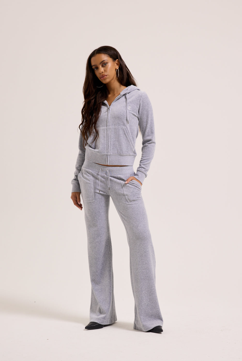 Woman wearing a gray tracksuit on a white background