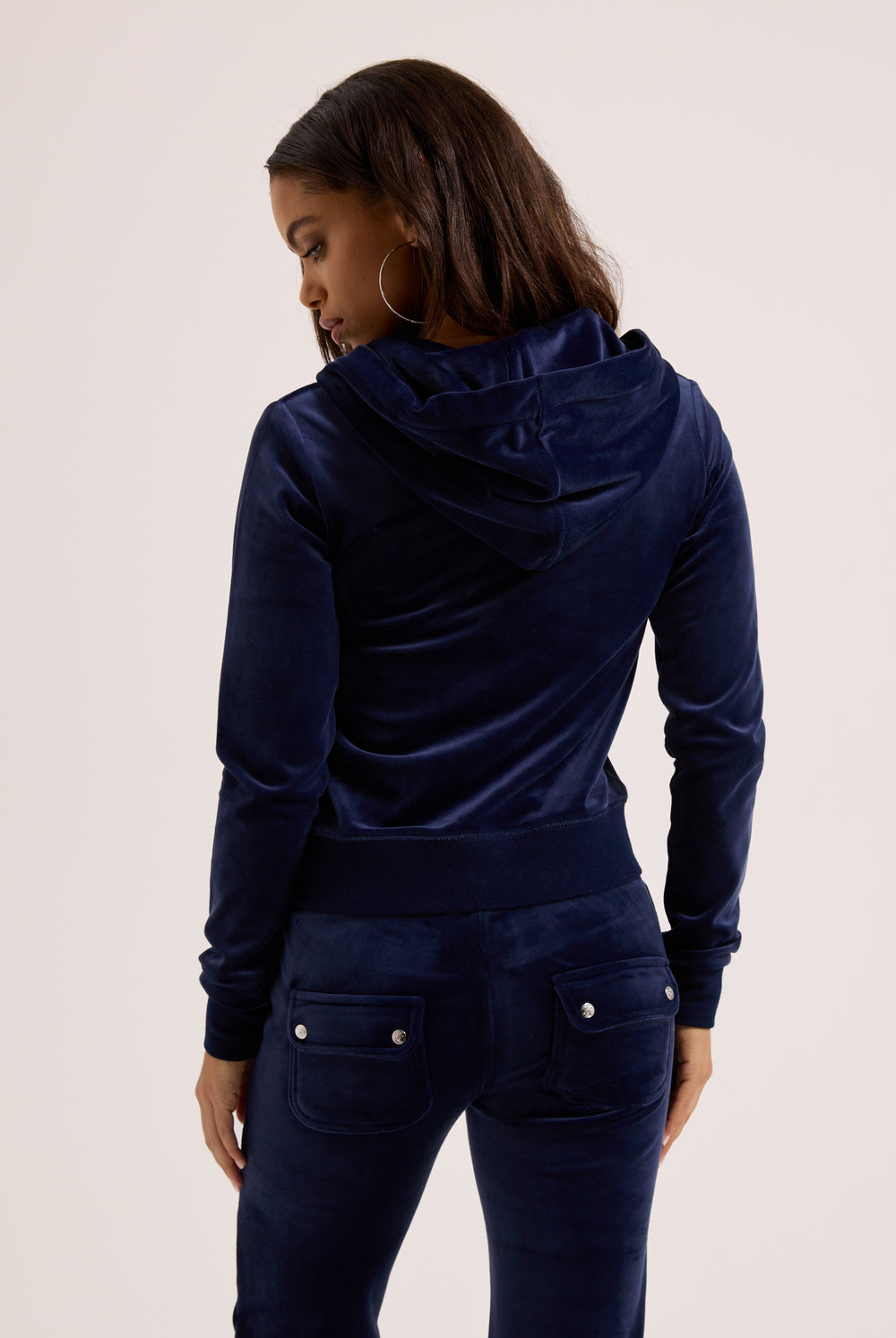 Person wearing a navy blue tracksuit on a light background