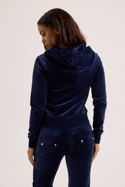 Person wearing a navy blue tracksuit on a light background