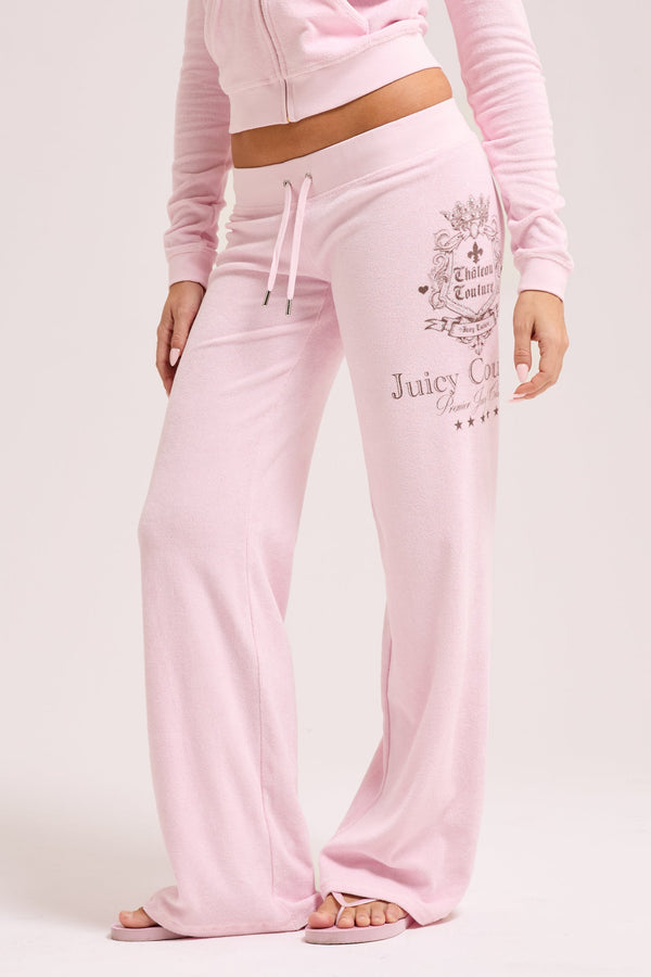 Displays a model wearing the Cherry Blossom 'Juicy' branded Chateau Terry Towelling Trackpant 
