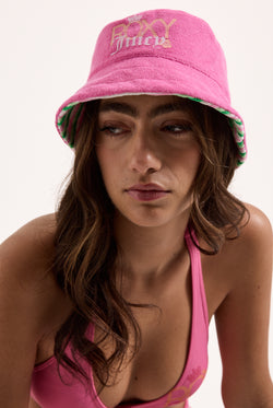 Displays a model wearing the Azalea pink Roxy & Juicy couture reversible bucket hat  