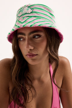 Displays a model wearing the Azalea pink Roxy & Juicy couture reversible bucket hat  