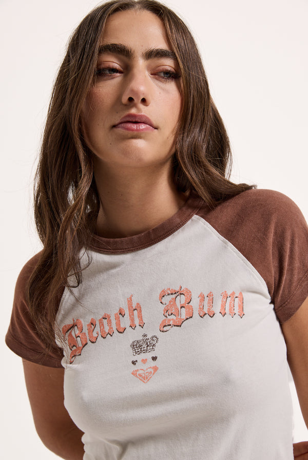 Displays a model wearing the Coconut Milk Roxy & Juicy Couture raglan graphic tee 