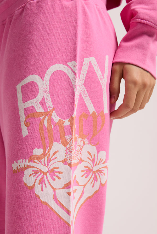 Displays a model wearing the Pink Azalea Roxy & Juicy Couture relaxed jorts featuring the Roxy x Juicy Couture logo 