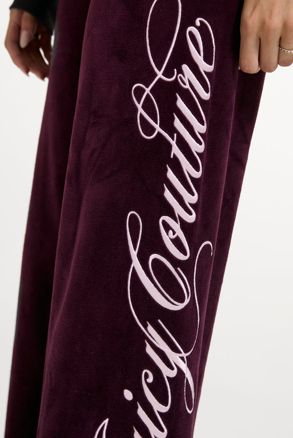 Displays a model wearing the Winetasting 'Juicy' branded Cotton Velour Ultra Lowrise Straight Leg Trackpant