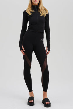 Displays a model wearing the Black 'Juicy' branded black rib peached interlock active legging 
