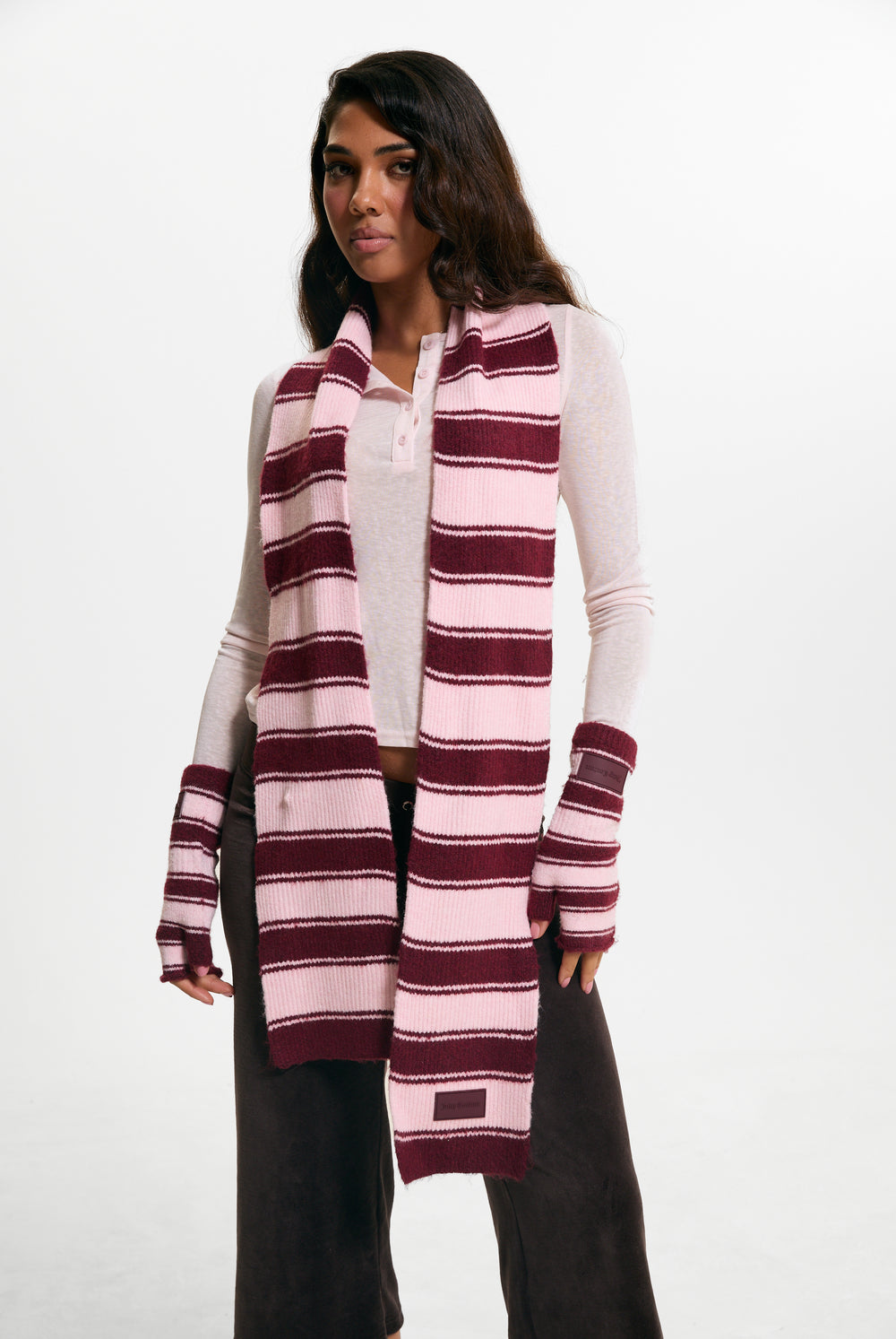 Displays a model wearing the Burgundy 'juicy' branded Stripe Knit Scarf
