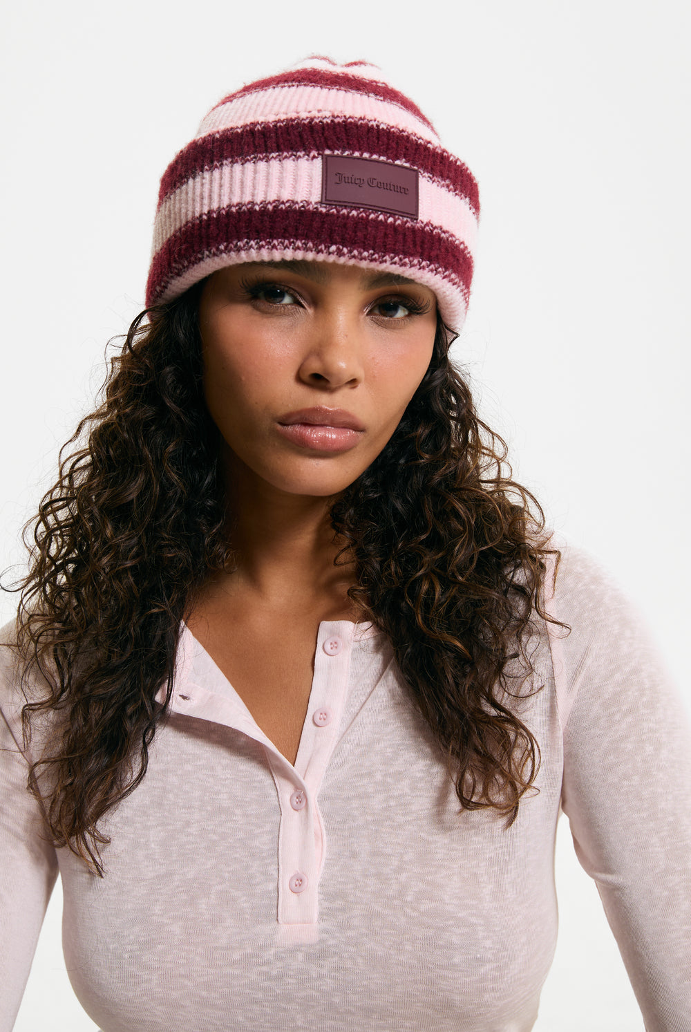 Displays a model wearing the Burgundy Stripe 'Juicy' branded Ribbed Beanie