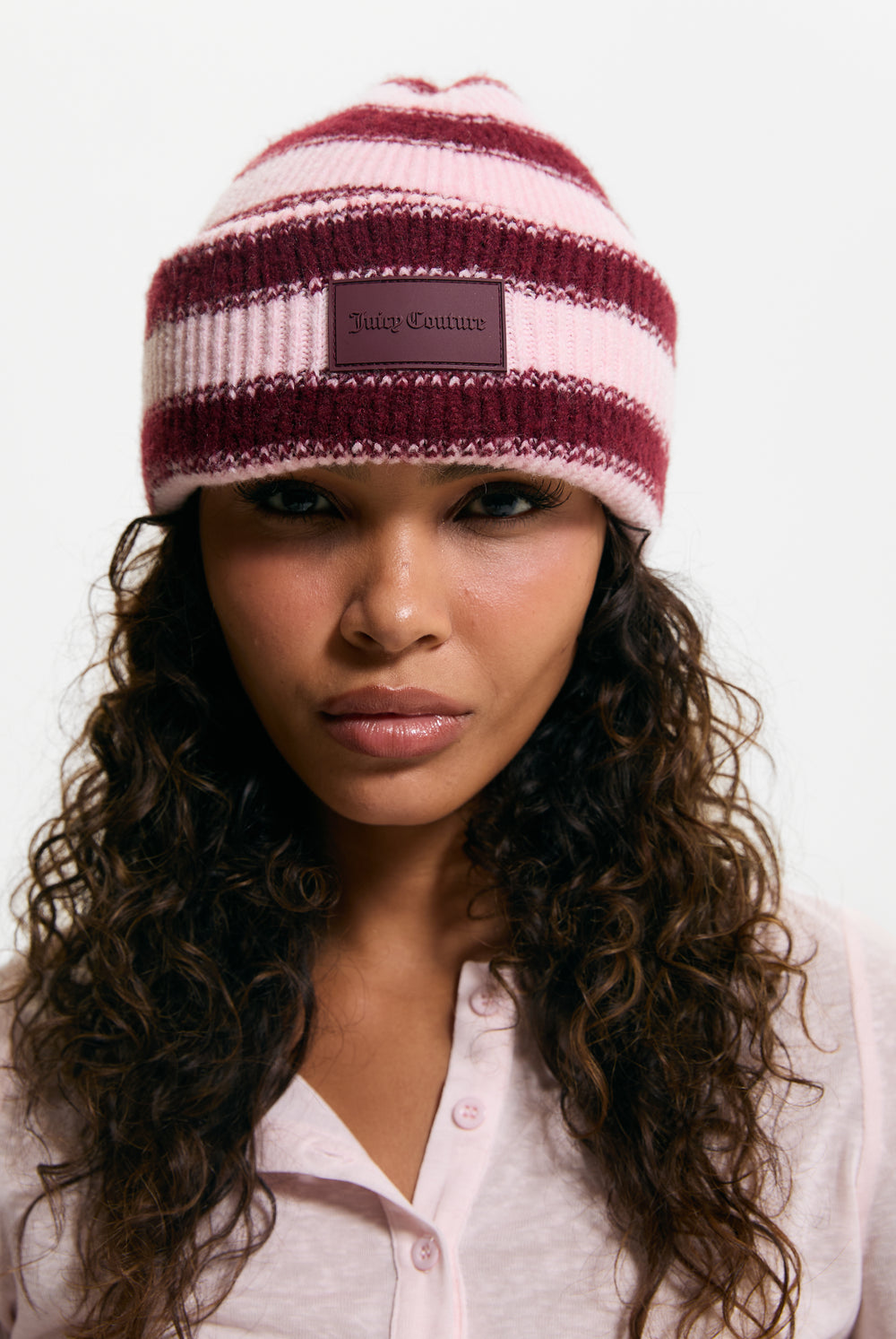 Displays a model wearing the Burgundy Stripe 'Juicy' branded Ribbed Beanie