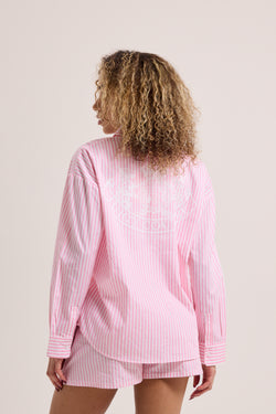 Displays a model wearing the Pink stripe 'Juicy' branded loungewear oversized shirt 