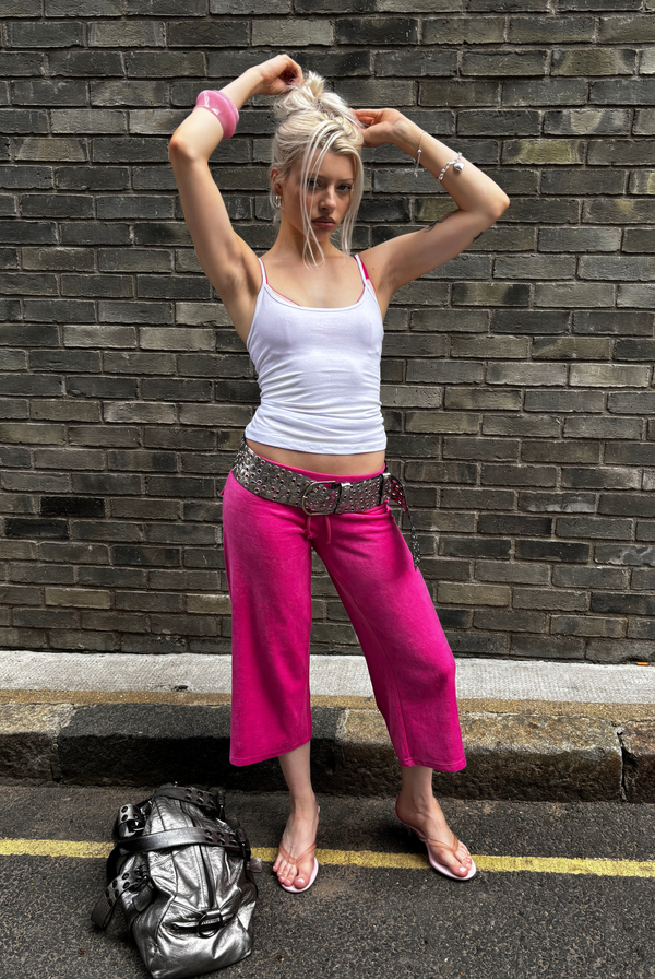 Displays a model wearing the Nostalgia Pink 'juicy' branded OG straight pocketed capri pants 