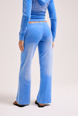 Displays a model wearing the Regatta washed 'Juicy' branded OG straight track pant
