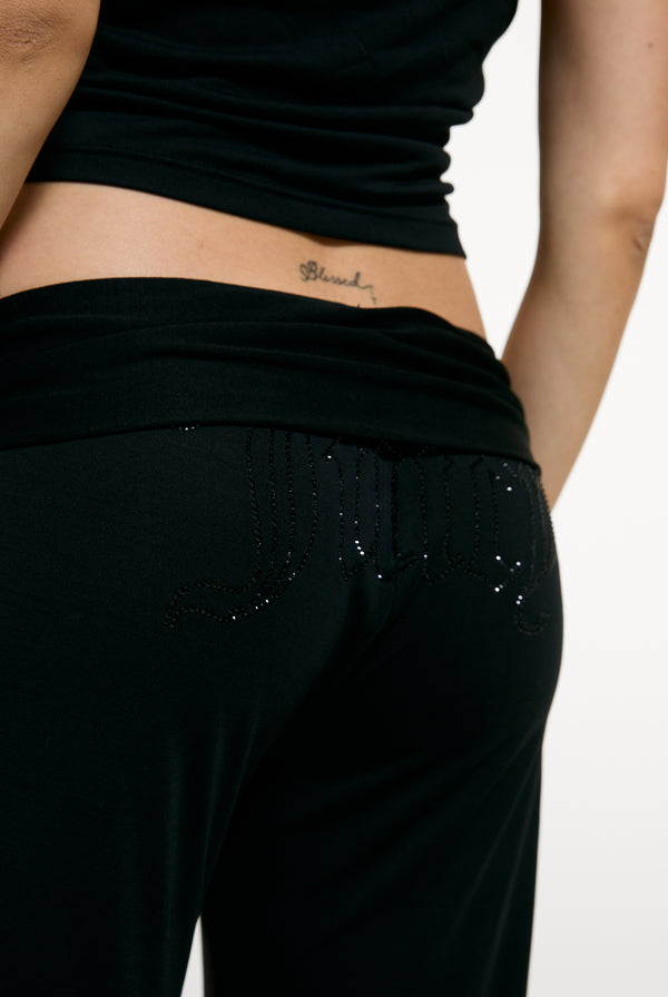 Displays a model wearing the Black 'Juicy' branded Belted Flare Trousers