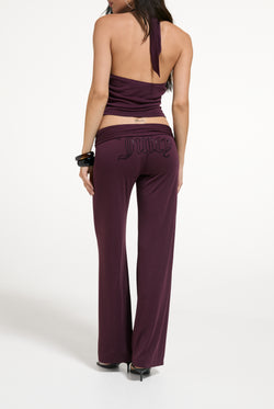 Displays a model wearing the Winetasting 'Juicy' branded Belted Flare Trousers