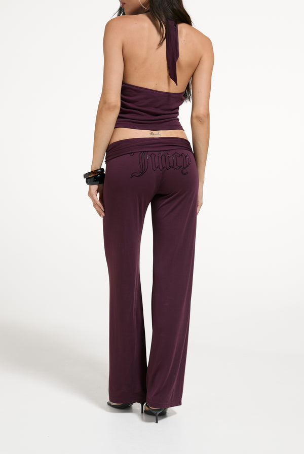 Displays a model wearing the Winetasting 'Juicy' branded Belted Flare Trousers